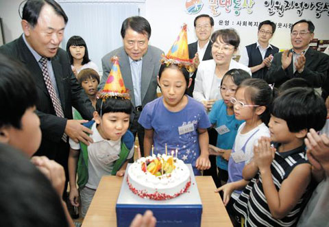 회색 양복을 입은 한국전력공사 김쌍수 사장(사진 가운데)이 서울 강남구 일원동 물댄동산 지역아동센터에서 생일을 맞은 아이들을 축하해주고 있다. /한국전력공사 제공