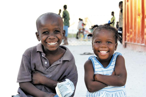재건사업이 한창인 아이티 수도 포르토프랭스 아이들이 저녁 급식 후 웃고 있다. 이 아이들의 웃음을 지키기 위해서는 아이티에 대한 지속적인 도움의 손길이 필요하다. /굿네이버스 제공