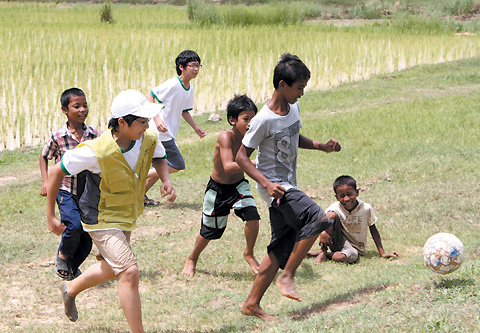 캄보디아 빈민촌 롤루어 마을 공터에서 굿네이버스 지구촌 희망편지 쓰기 대상이었던 락스미 형제와 편지를 써 수상한 어린이들이 함께 축구를 하고 있다. 오른쪽에서 두 번째 뛰고 있는 캄보디아 소년이 락스미다. /굿네이버스 제공