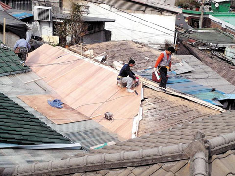 성북구의 마을기업 ‘동네목수’ 직원들이 노후 주택의 지붕을 고치고 있다. /동네목수·두꺼비하우징 제공