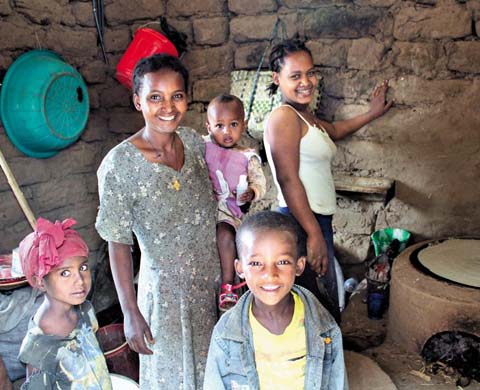 에티오피아 아둘랄라 마을의 한 가정이 새 화덕이 설치된 부엌에 모여 미소를 지어보이고 있다.