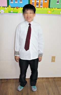 중학교 1학년인 정우(가명)가 교복을 입고 있는 모습. 왜소한 체구 때문에 교복이 몸에 비해 너무 크다.