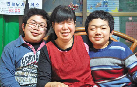 뮤코다당증을 앓고 있는 주호, 주완이 형제가 어머니와 함께 환한 미소를 짓고 있다.