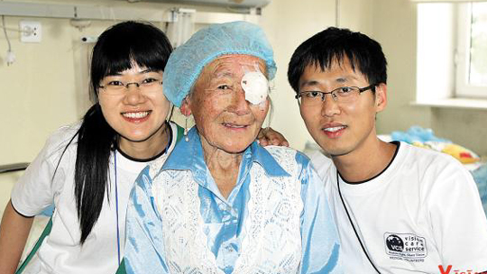몽골 의료봉사에서 안과시술을 받은 할머니와 찍은 부부의 사진. /비전케어 제공