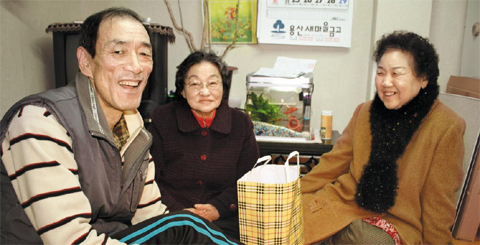 김덕한(사진 왼쪽)씨를 찾은 현옥분(가운데)씨와 김재흠씨가 종이 봉투에 담긴 설 선물을 건네며 이야기를 나누고 있다.