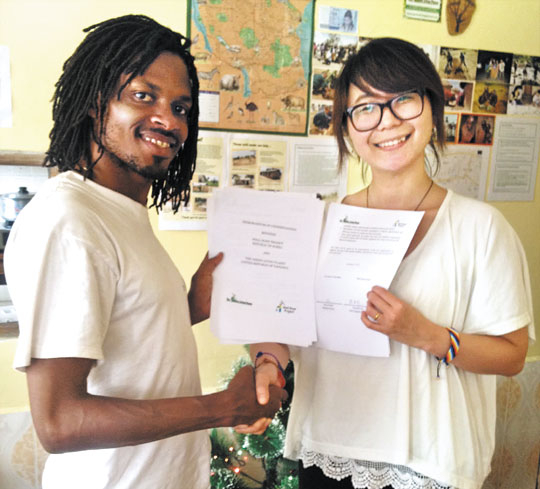 디자이너 조동희(오른쪽)씨가 탄자니아 현지 NGO인 ‘그린리빙플래닛’의 대표(왼쪽)와 만나 산수책 공동판권 협약을 체결했다. /웰던프로젝트 제공