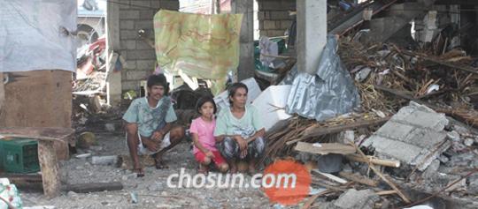 지난 8일, 태풍 하이옌이 불어닥친 자리엔 건물 잔해들만 남았다. 폐허로 변해버린 집 더미에 웅크리고 앉은 가족들이 허망한듯 먼바다를 바라보고 있다. /정유진 기자