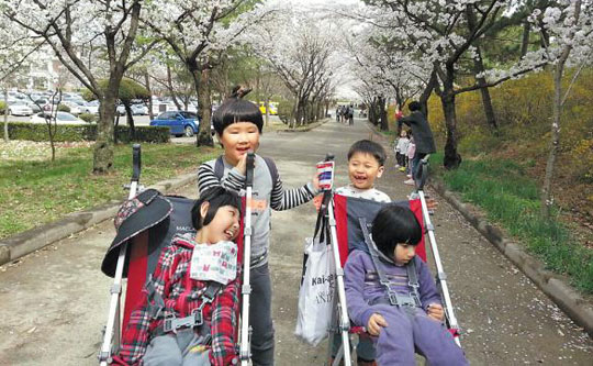 한사랑어린이집의 아이들은 장애·비장애 구분 없이 함께 자라난다. 자기 키만 한 장애아용 유모차를 뒤에서 밀고 끌어주면서 서로를 이해하고 배려한다. /한사랑어린이집 제공