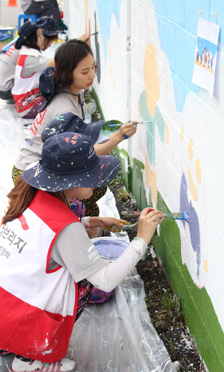 희망브리지 '집수리로드' 자원봉사자들이 벽화를 칠하고 있는 모습. /희망브리지제공