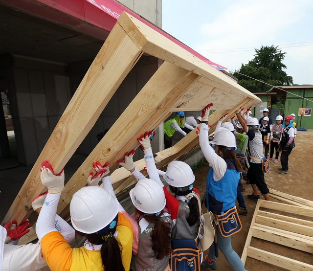 2015년 춘천현장에서 봉사하고 있는 이화여대 해비타트 동아리- 벽체를 들어올리고 있다