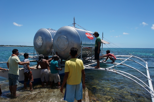 스테인레스 재질의 빗물 저장 탱크를 들여오는 힐루퉁안 섬 주민들.ⓒ전국재해구호협회