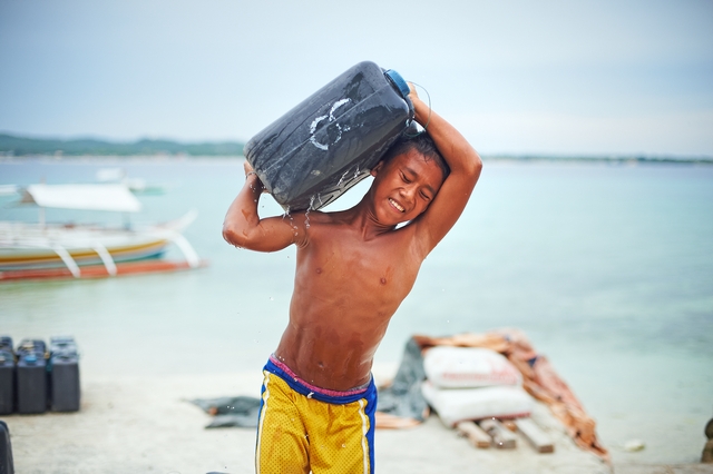 힐루퉁안 섬 아이들이 약 20kg 무게의 물통을 짊어 나르고 있다.ⓒ전국재해구호협회