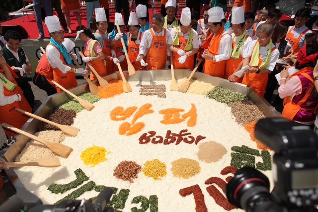지난 2014년, 밥퍼 700만 그룻 돌파 기념식 행사에서 참석자들이 대형 비빔밥을 만들고 있다. ⓒ다일공동체