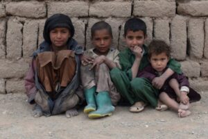 탈레반 집권 후 최악의 경제난에 시달리고 있는 아프가니스탄 중서부 헤라트주에 있는 한 난민캠프에서 20일(현지 시각) 어린이들이 벽돌로 지어진 임시 가옥 앞에 앉아 있다. /AFP 연합뉴스
