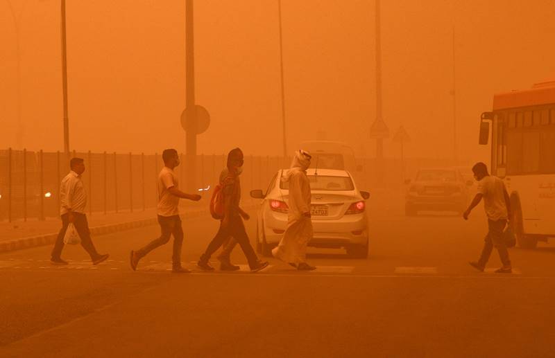 23일(현지 시각) 쿠웨이트 수도 쿠웨이트시티에서 시민들이 주황색 먼지가 가득찬 거리를 걷고 있다. /EPA 연합뉴스