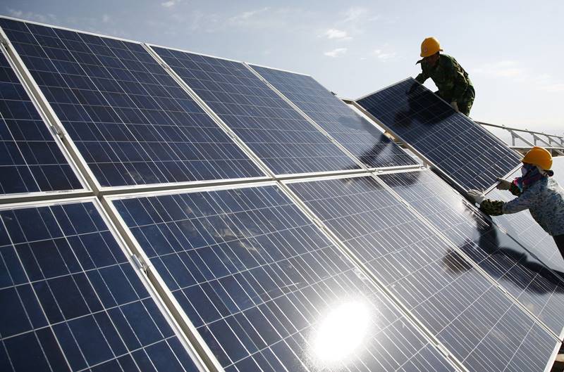 중국 신장 위구르 자치구의 한 태양광발전소에서 노동자들이 태양광 패널을 설치하고 있다. /AP 연합뉴스