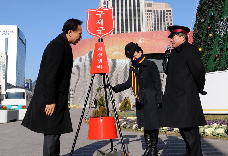 2009년 12월 16일 이명박 전 대통령이 서울광장에 설치된 구세군 자선냄비에 성금을 내고 구세군사관을 격려하는 모습. /청와대사진기자단