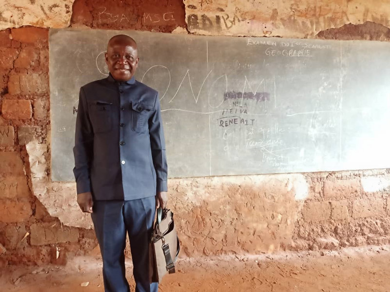 지난 2월 17일(현지 시각) 탄자니아 냐루구수 난민캠프에서 만난 네스토리 음야(64)씨. 그가 1990년대에 직접 벽돌을 쌓아올려 지은 초등학교의 칠판 앞에서 미소 짓고 있다. /탄자니아=김소희 해외통신원
