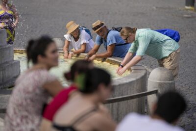 23일(현지 시각) 이탈리아 로마를 찾은 관광객들이 분수에 손을 담그고 더위를 식히고 있다. 이날 이탈리아 전역이 40도에 달하는 폭염에 시달렸다. /AP 연합뉴스