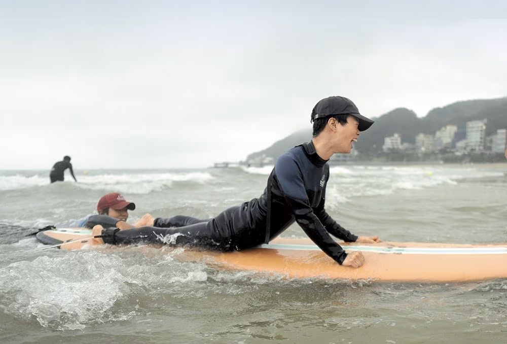 뇌성마비 장애인 고숙희(31)씨가 서프보드를 타고 해변으로 미끄러지듯 들어오고 있다. /하루하루움직임연구소