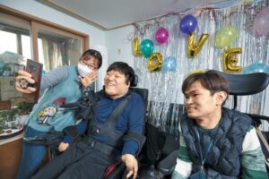 지난달 15일 서울 영등포구 자립주택에서 열린 크리스마스 파티에서 뇌병변과 지적장애가 있는 이용수(가운데)씨가 친구와 영상 통화를 하고 있다. /한준호 C영상미디어 기자
